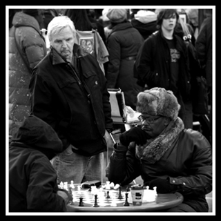 Una partita a scatti interetnica, con il giocatore incappucciato.
<br />la foto si chiama &quot;Chess&quot;
